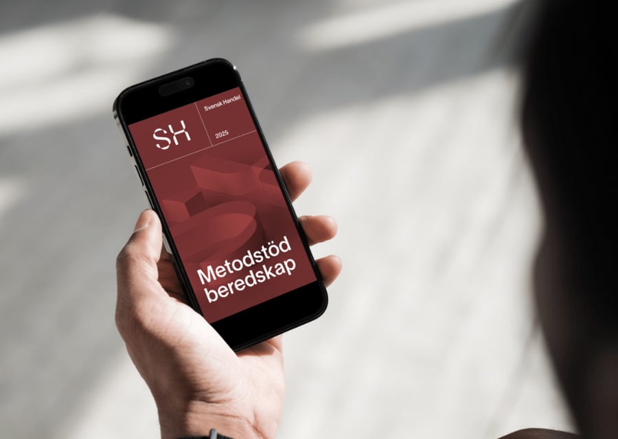 En person som håller en mobiltelefon i handen.