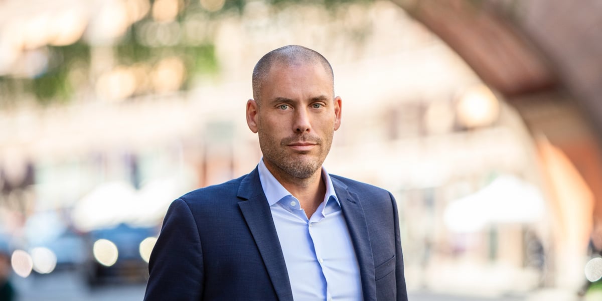 En kostymklädd man går längs gatan.