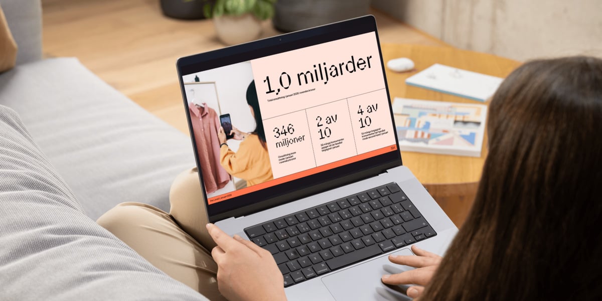 En kvinna sitter i en soffa och använder en bärbar dator.