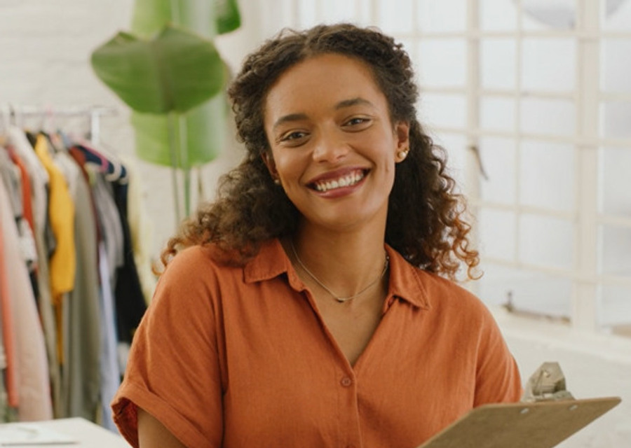 En kvinna står framför en hylla med skjortor.