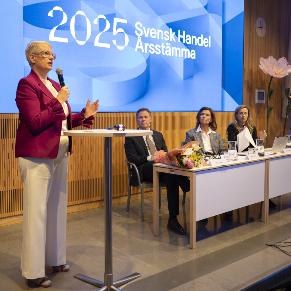 En kvinna som står på ett podium framför en grupp människor.