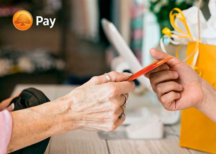 En person ger en annan person något med ett kreditkort.