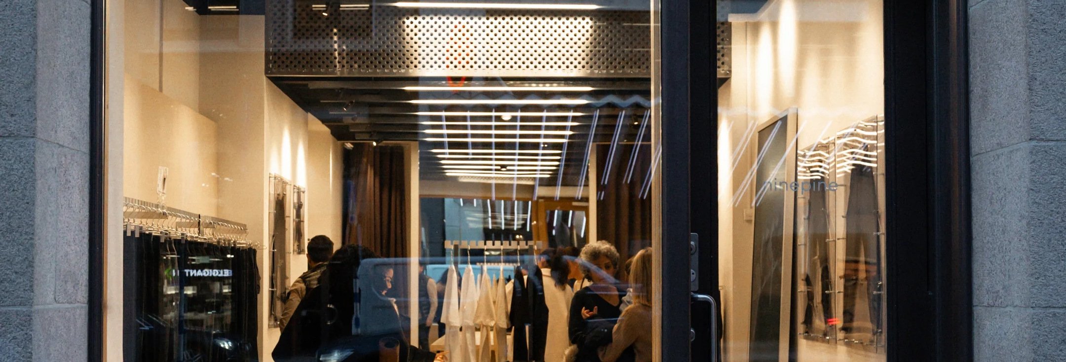 En grupp människor som står framför ett skyltfönster.