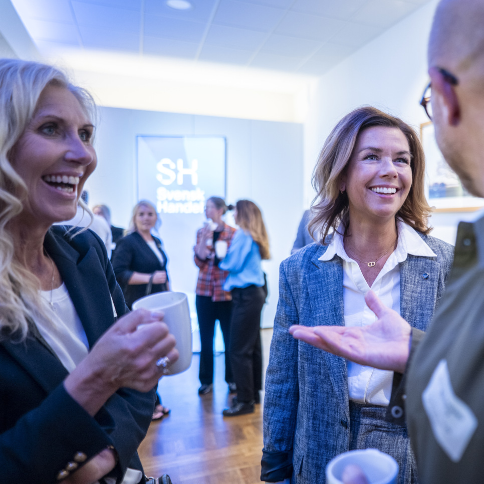 En grupp människor som står och pratar med varandra.