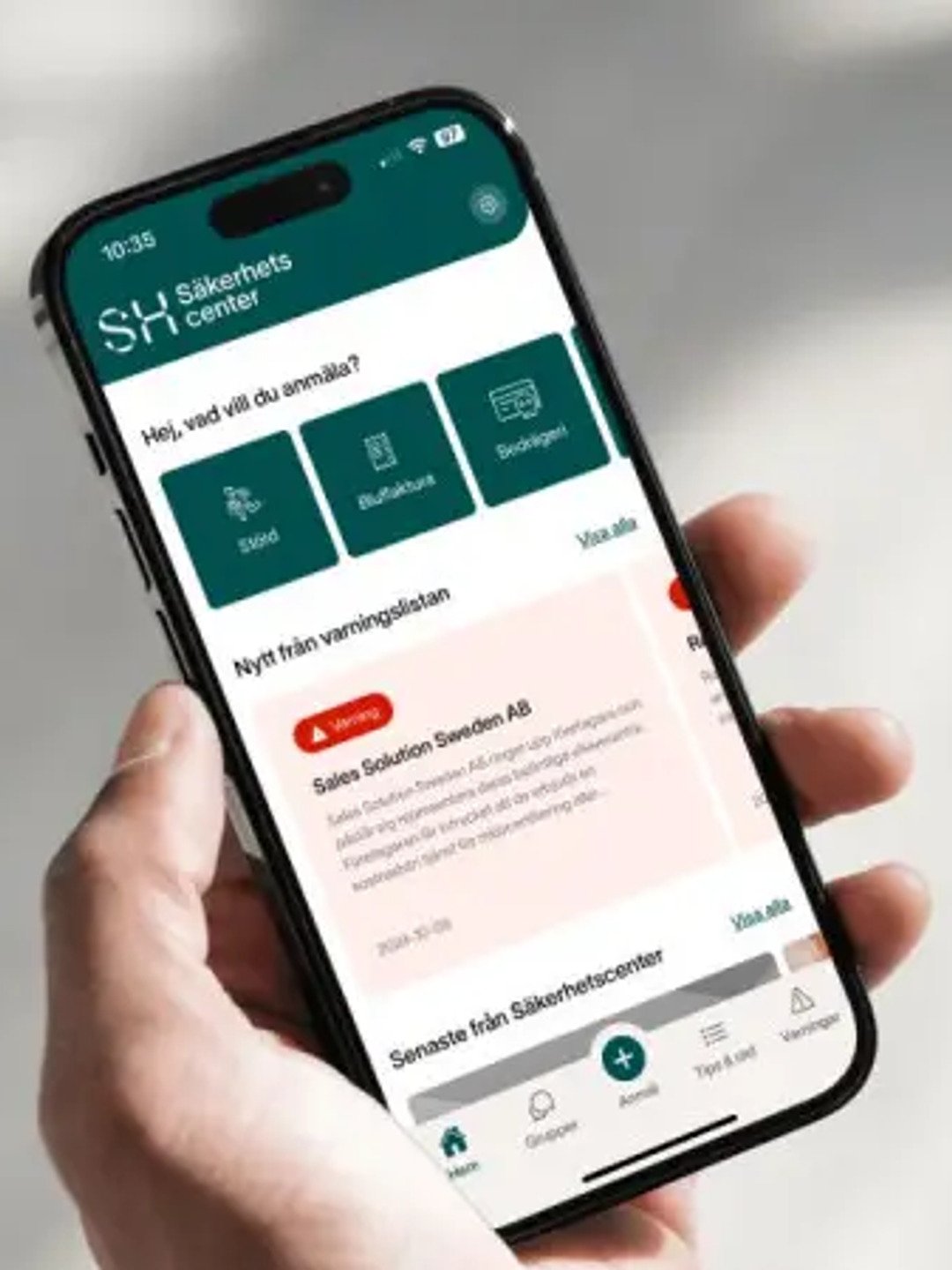 En person som håller en mobiltelefon i handen med appen Säkerhetscenter.