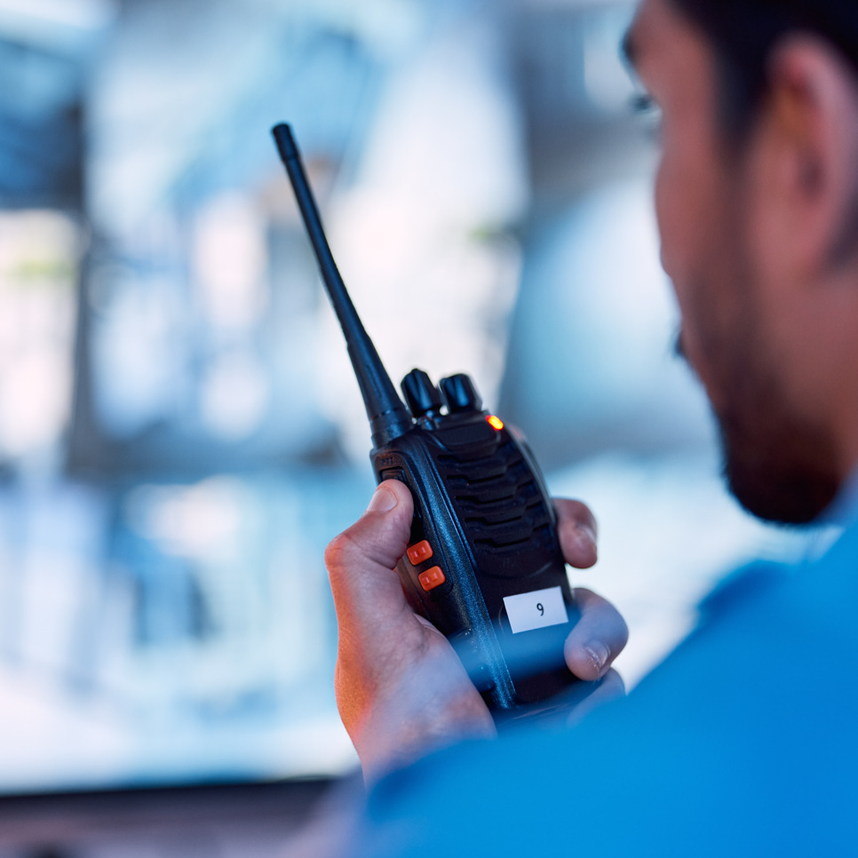 En man i blå skjorta håller i en radio.