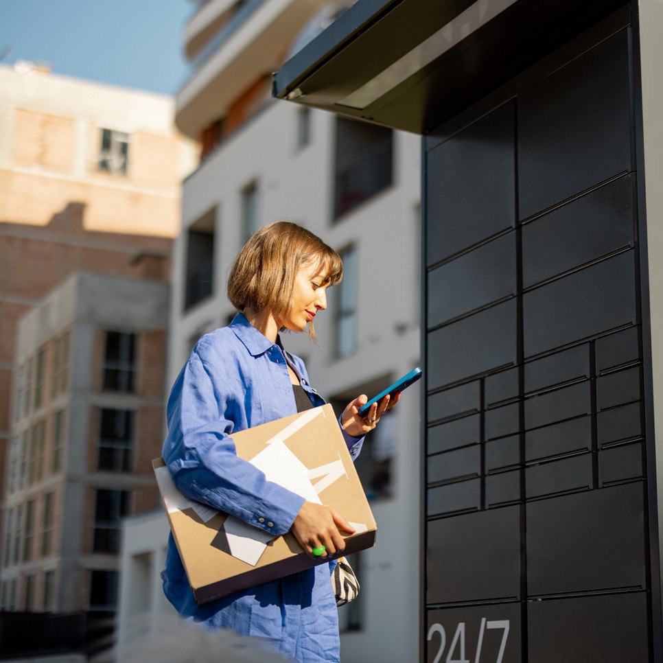 En kvinna i blå overall som använder en mobiltelefon.