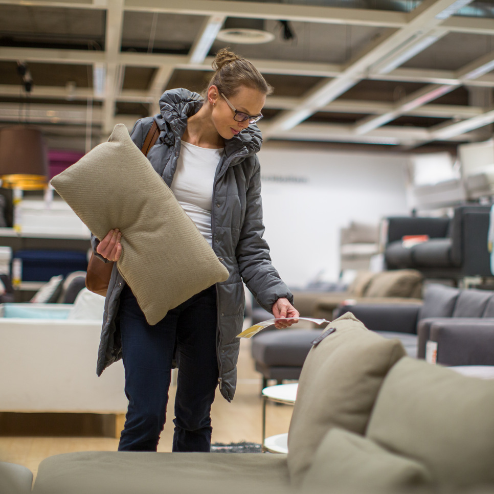 En kvinna tittar på en soffa i en möbelaffär.