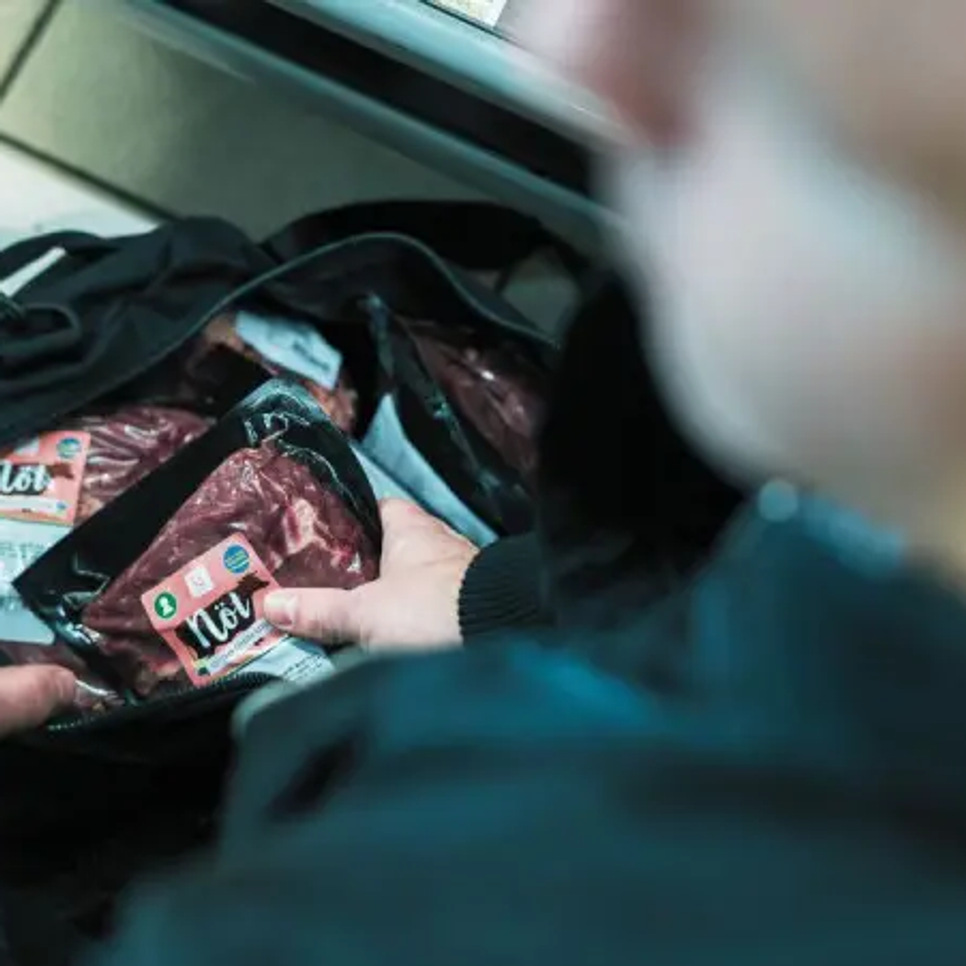 En man håller en påse med mat i sin hand.