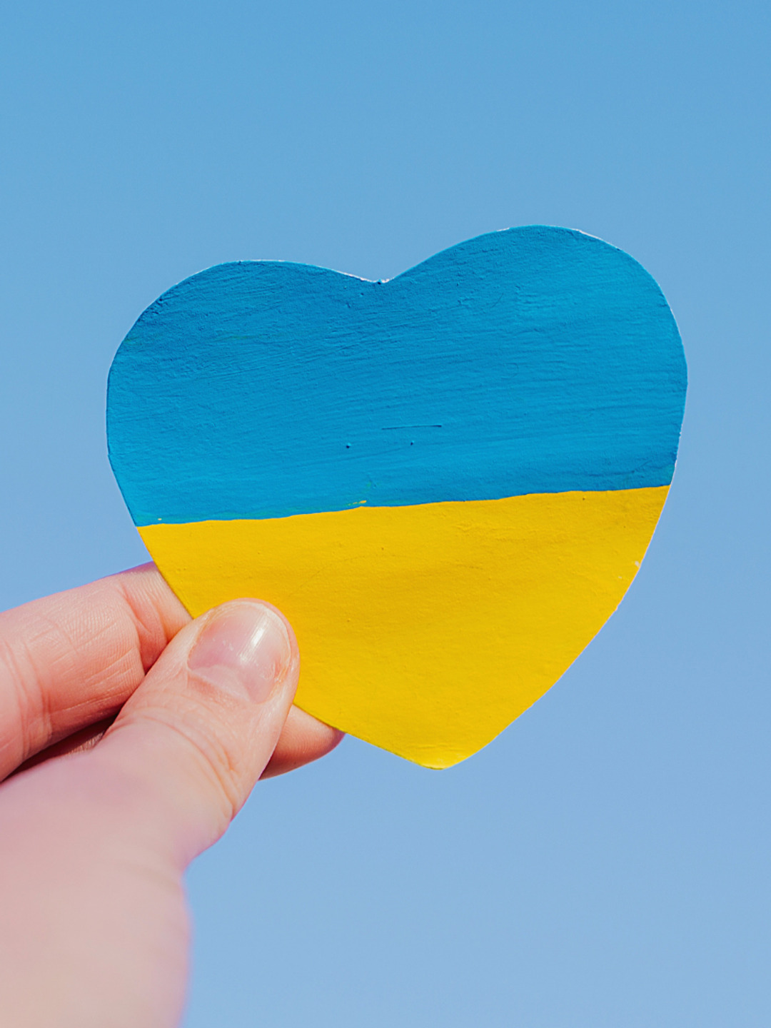 En hand som håller i ett papper i form av ett hjärta.