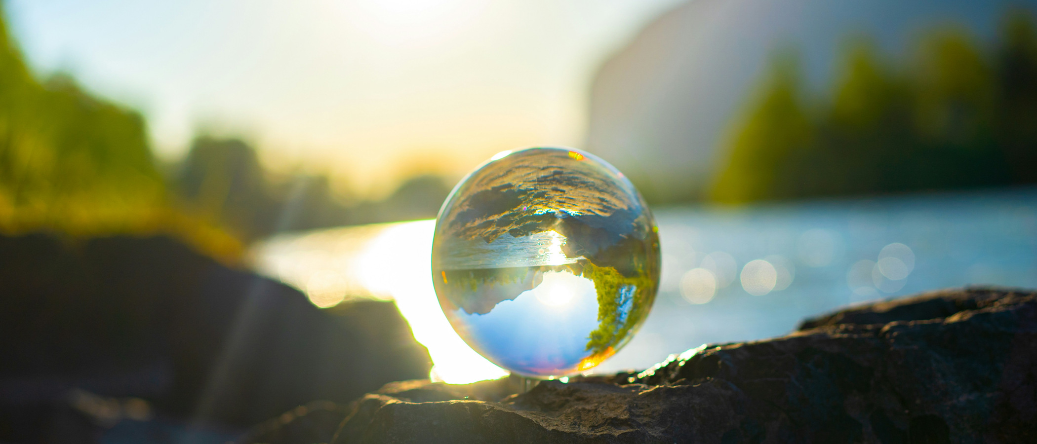 En glasglob som sitter på toppen av en sten.