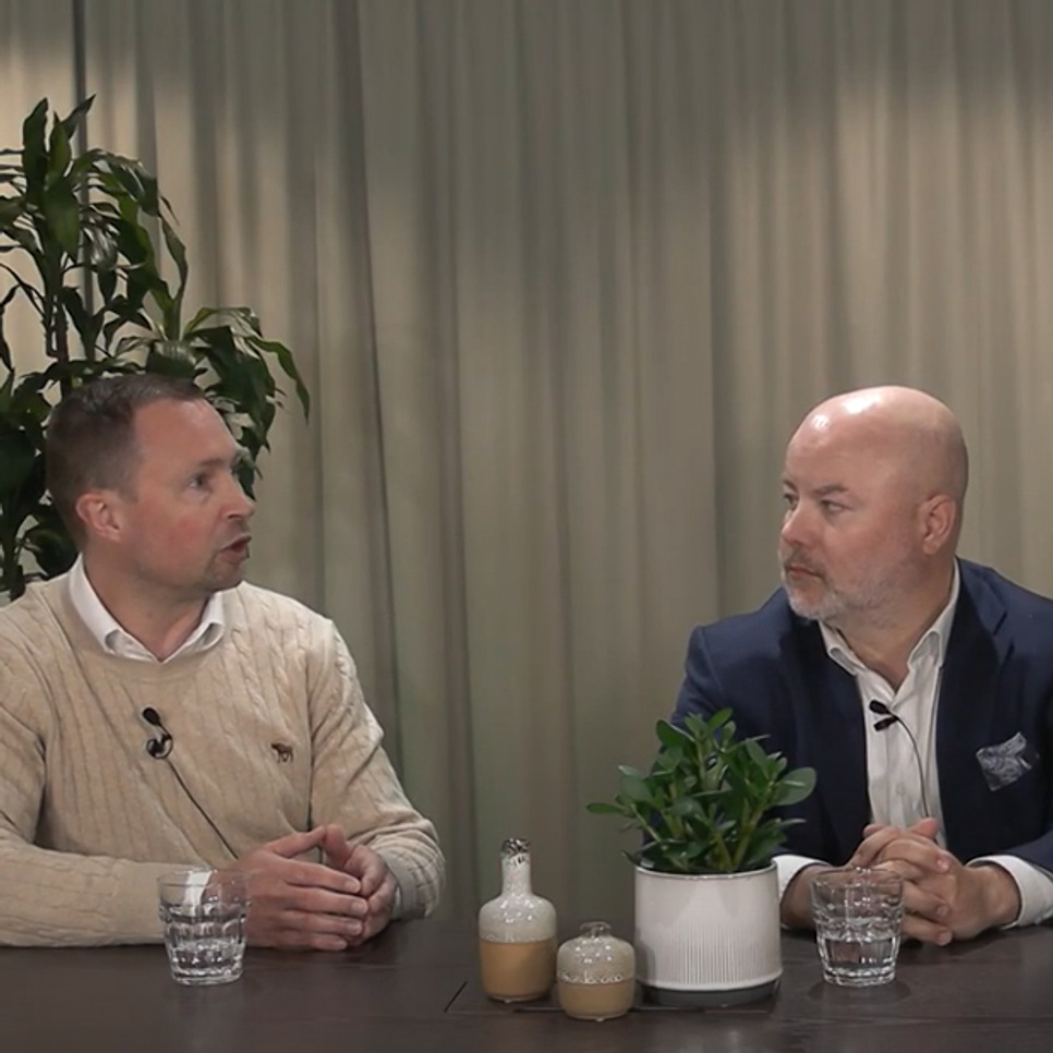 Tre personer som sitter vid ett bord och pratar med varandra.