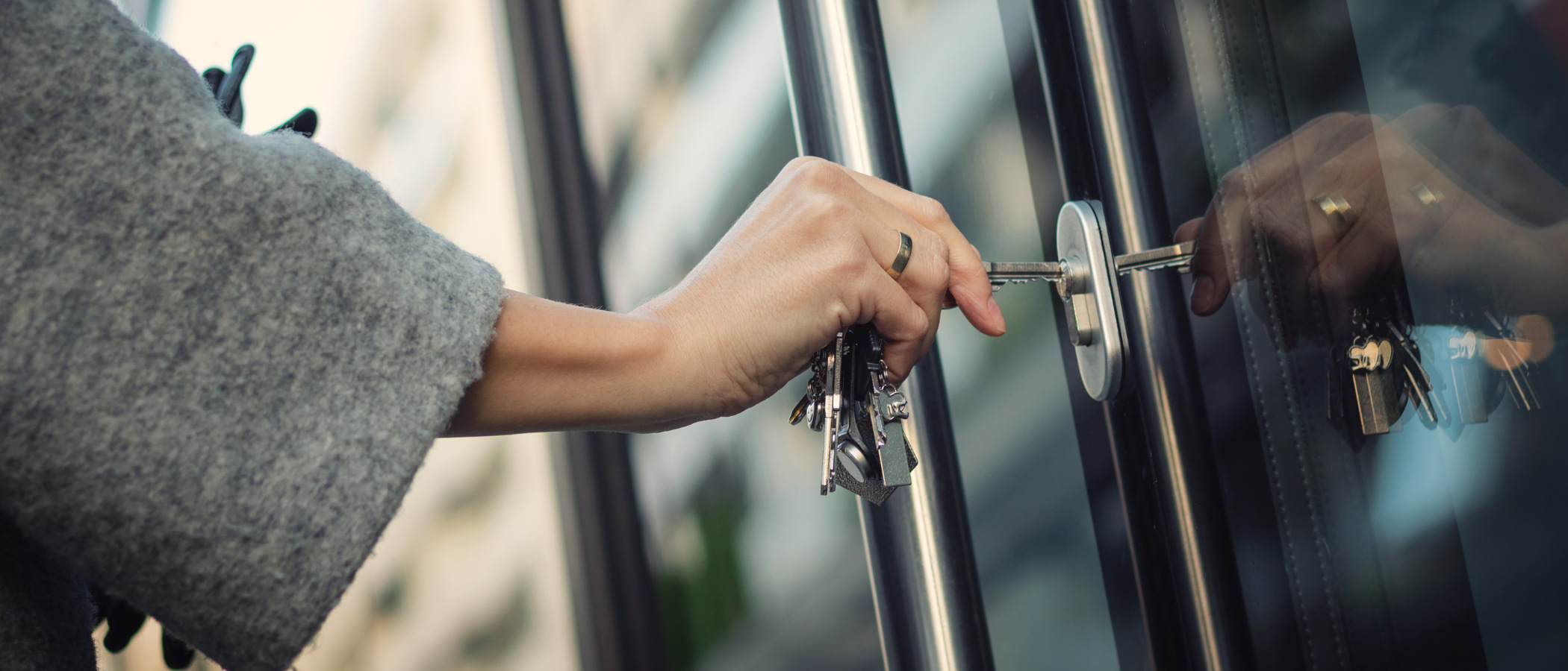 En närbild av en person som öppnar en glasdörr.