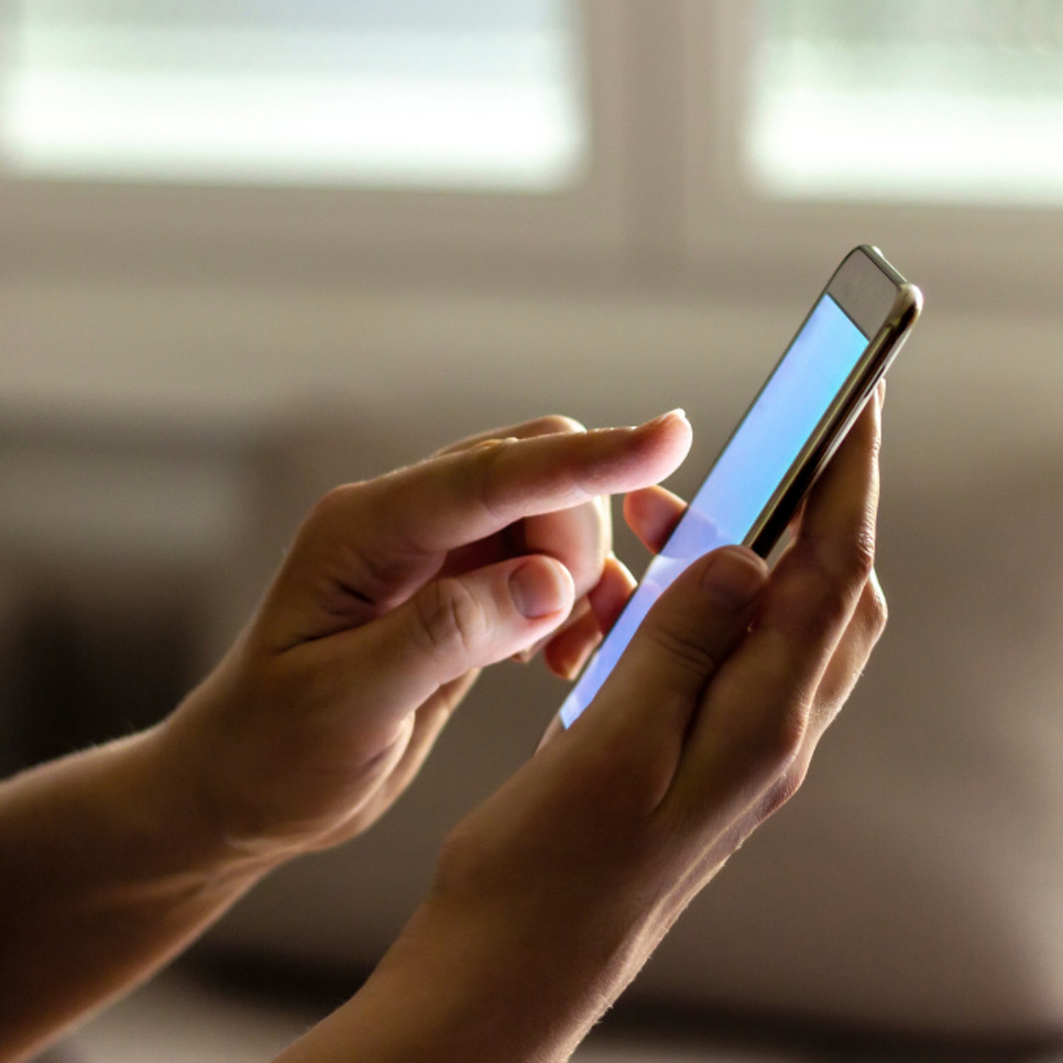 En person som håller en smart telefon i handen.