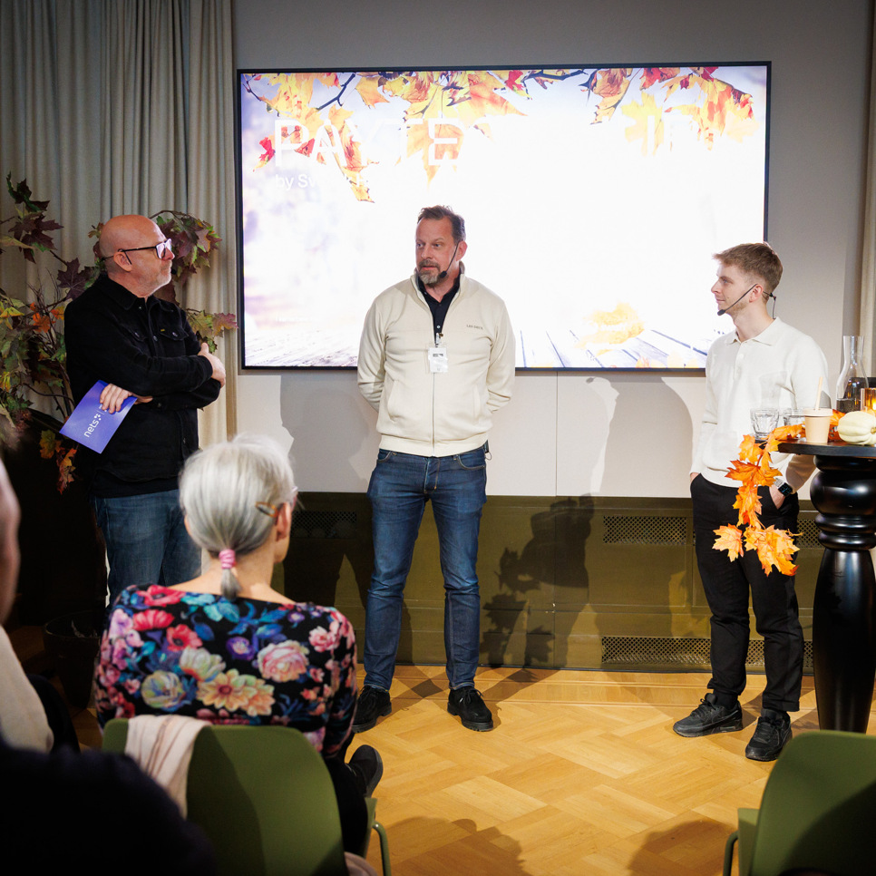 En grupp människor som står framför en projektorduk.