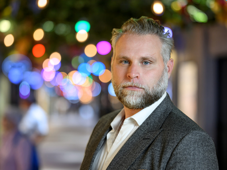 En man med skägg som bär kostym och slips.