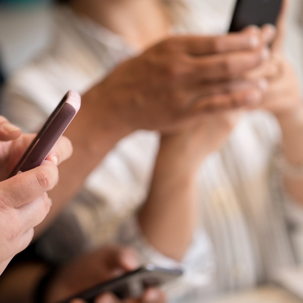 En grupp människor som använder sina mobiltelefoner.