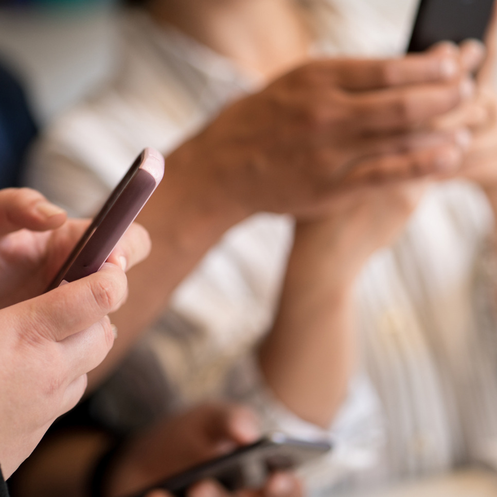 En grupp människor som använder sina mobiltelefoner.