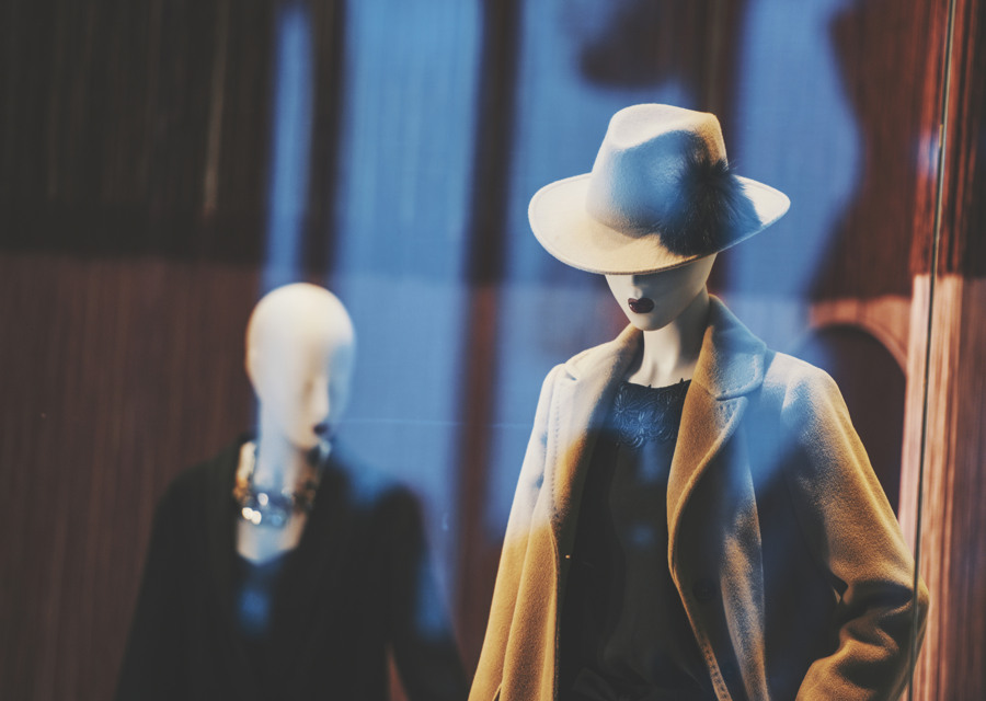 Två skyltdockor med hattar i ett skyltfönster.