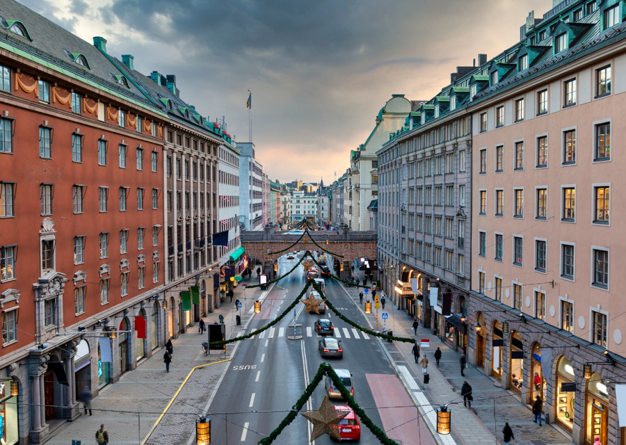 En gata i en stad med mycket trafik bredvid höga byggnader.
