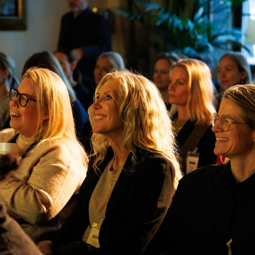 En grupp kvinnor som sitter bredvid varandra.