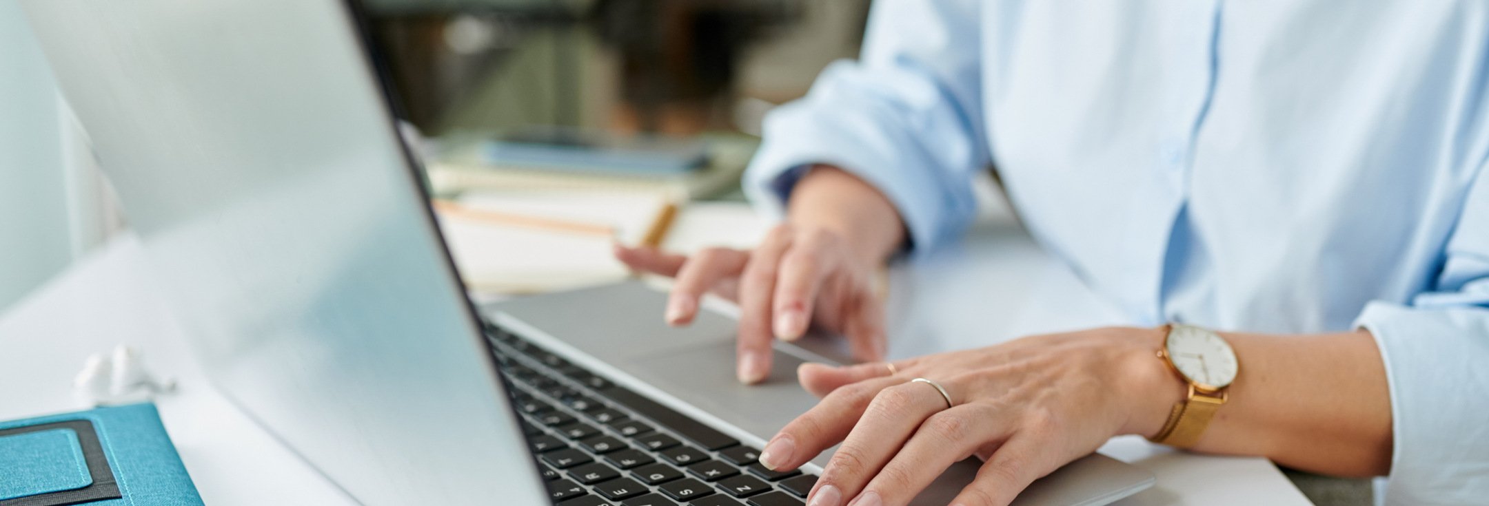 En kvinna sitter vid ett skrivbord och använder en bärbar dator.