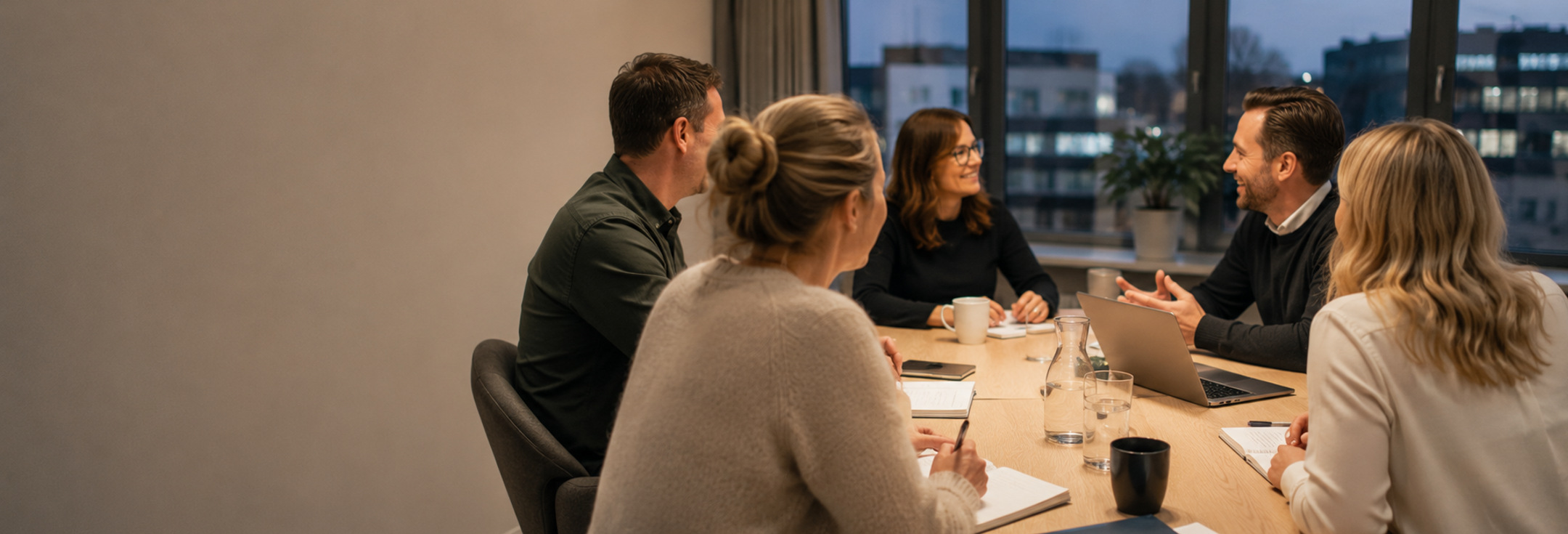 En grupp människor som sitter runt ett bord och pratar.