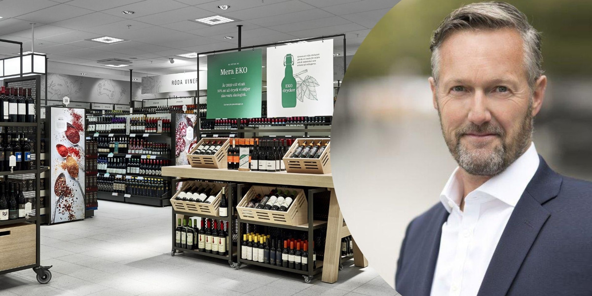 En man står framför en vinbutik.