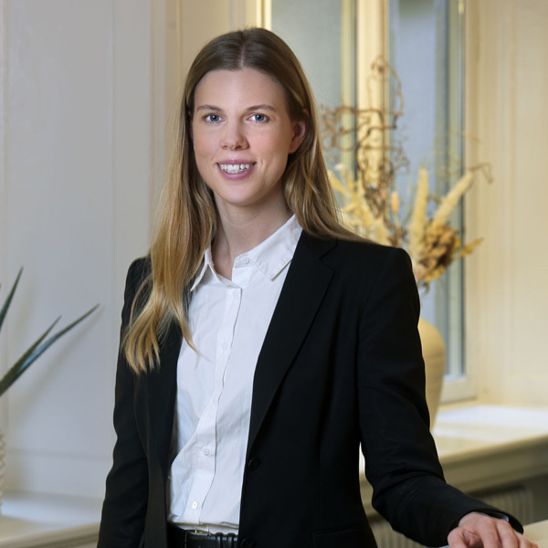 En kvinna som står framför ett fönster.