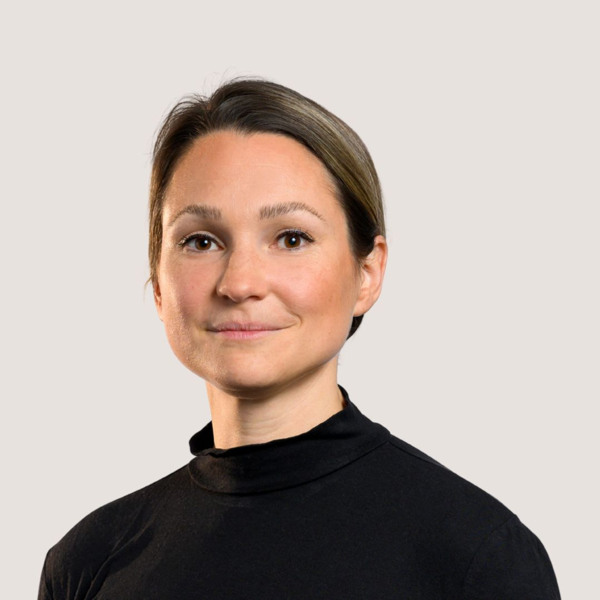 En kvinna i en svart tröja ler mot kameran.