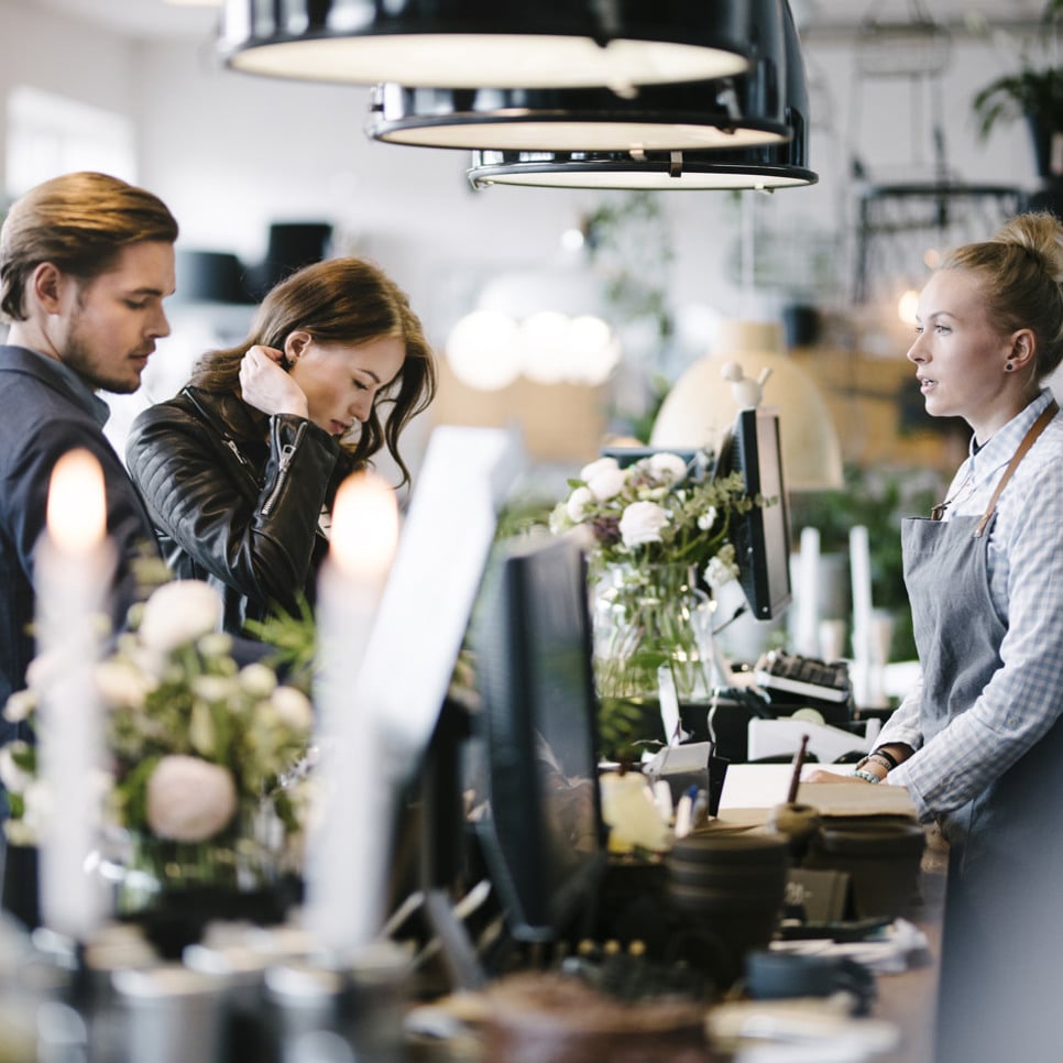 Några personer som står framför en disk i en butik.
