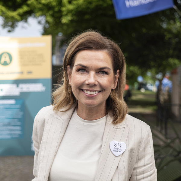 En kvinna står framför en byggnad.