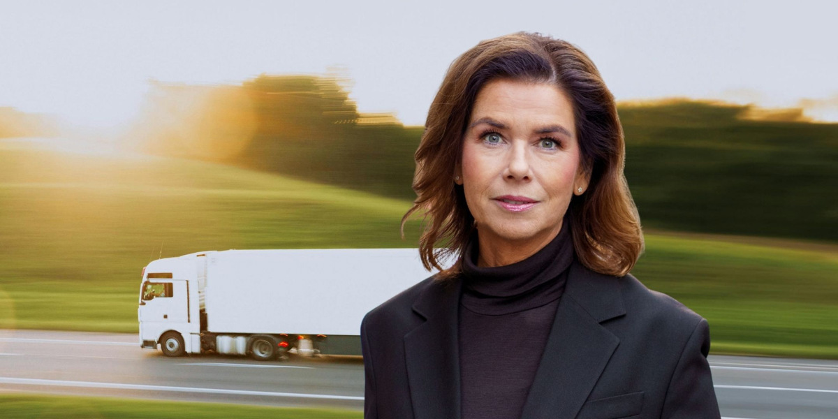 En kvinna i svart kostym och en vit lastbil.