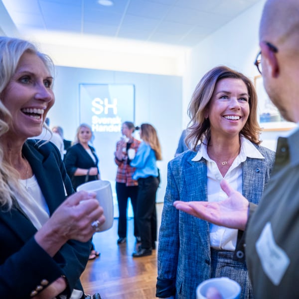 En grupp människor som står och pratar med varandra.