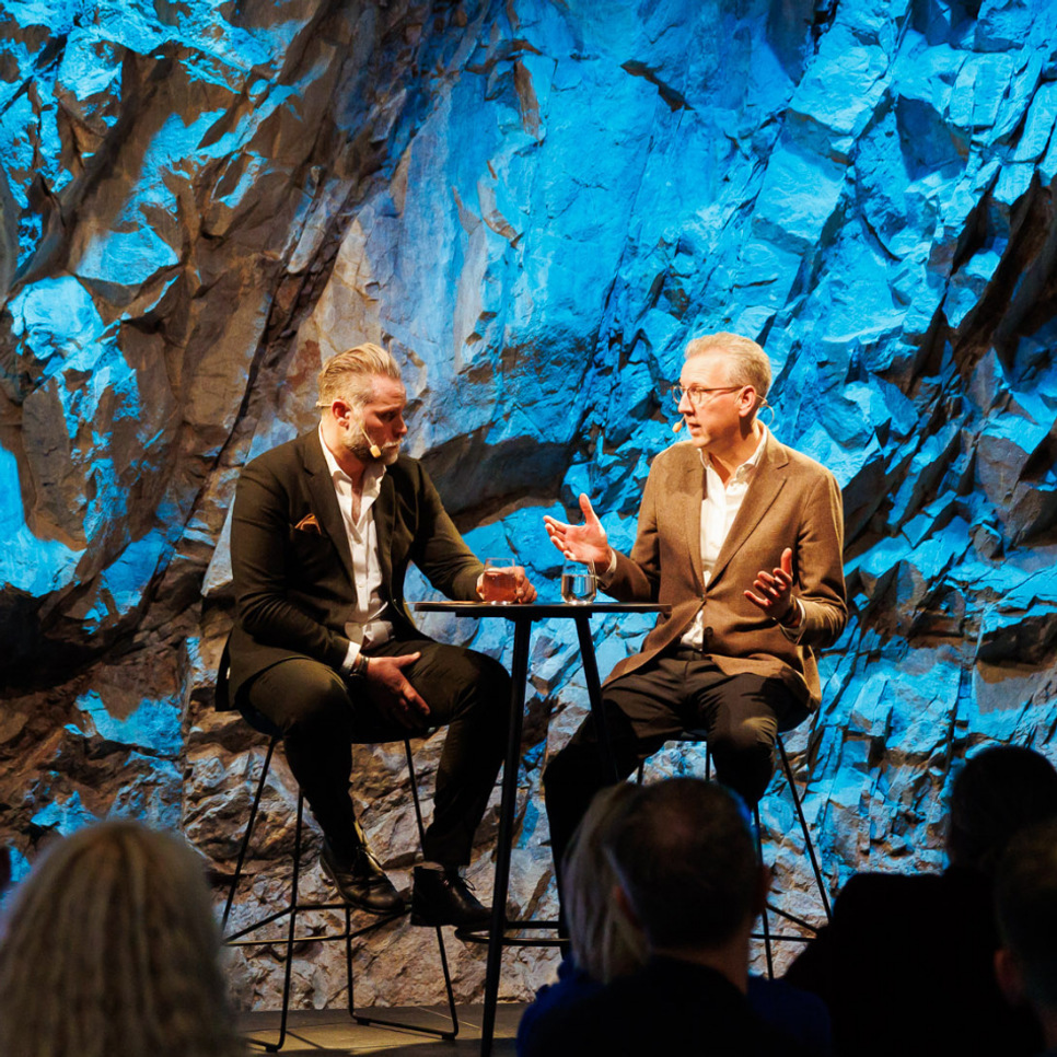 Några män som sitter bredvid varandra på en scen.