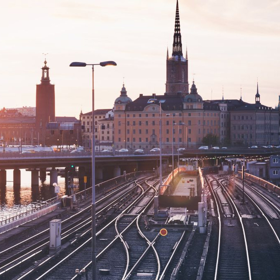 Ett tåg som färdas på järnvägsspår intill en flod.