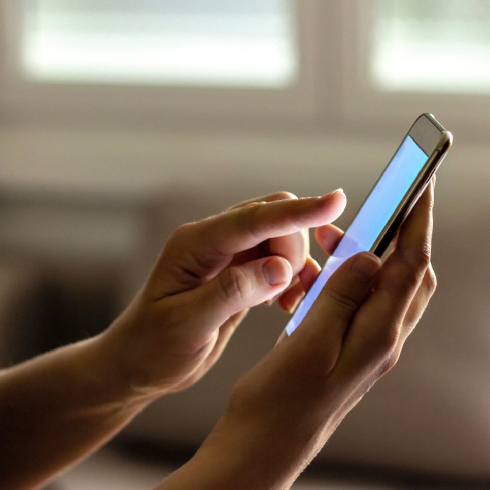 En person som håller en smart telefon i handen.