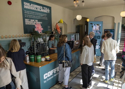 En grupp människor som står runt ett kafé.