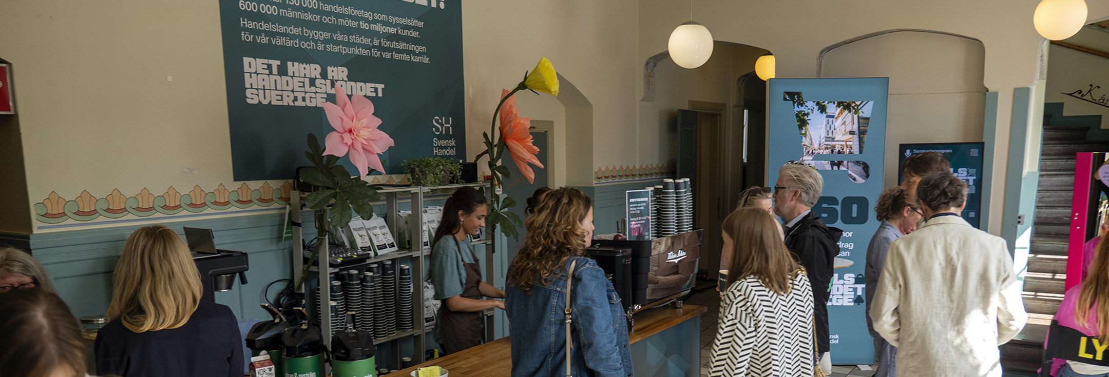 En grupp människor som står runt ett kafé.