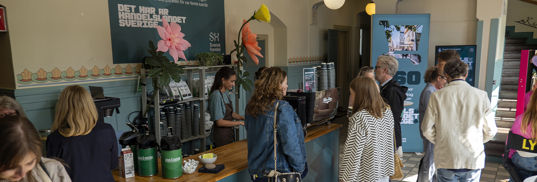 En grupp människor som står runt ett kafé.