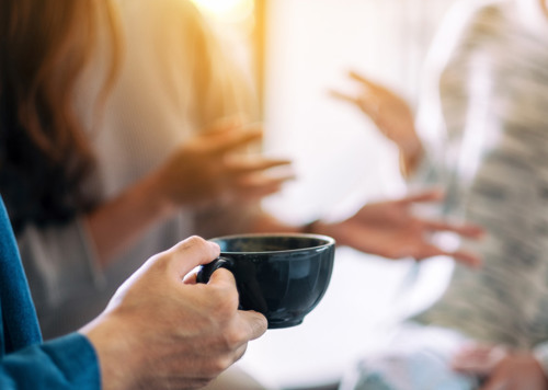 En person som håller en kaffekopp i sina händer.