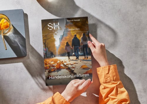 En person som sitter vid ett bord och läser en bok.