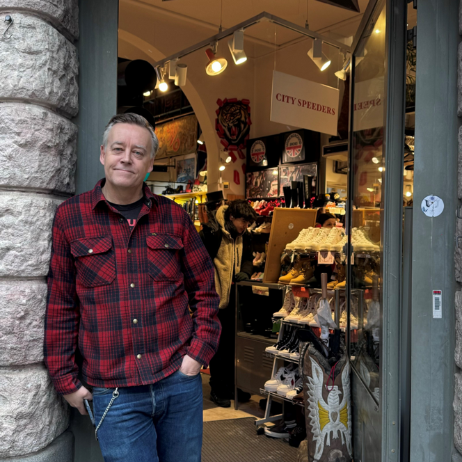 En man som står i dörröppningen till en butik.