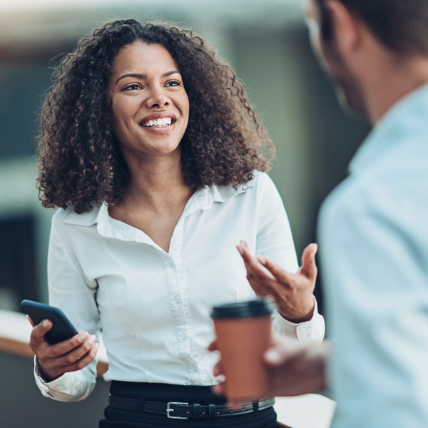 En kvinna pratar med en man i vit skjorta.