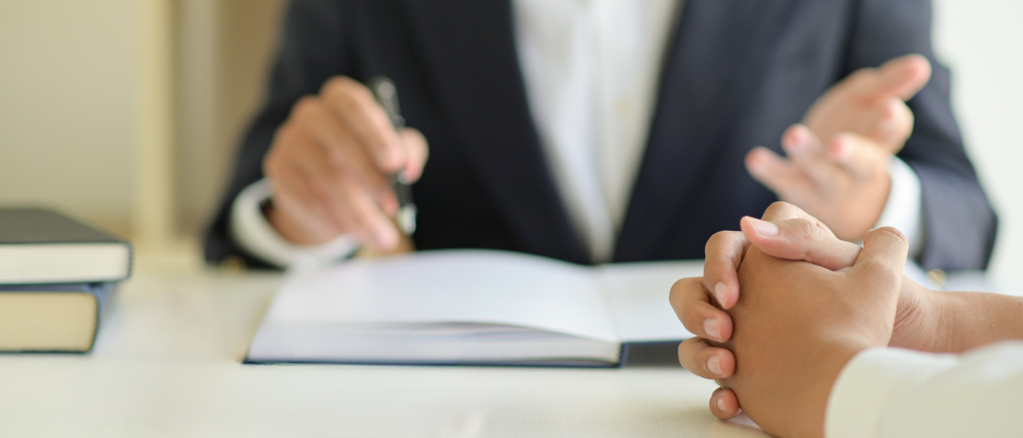 Två personer sitter vid ett bord med en bok och en penna.