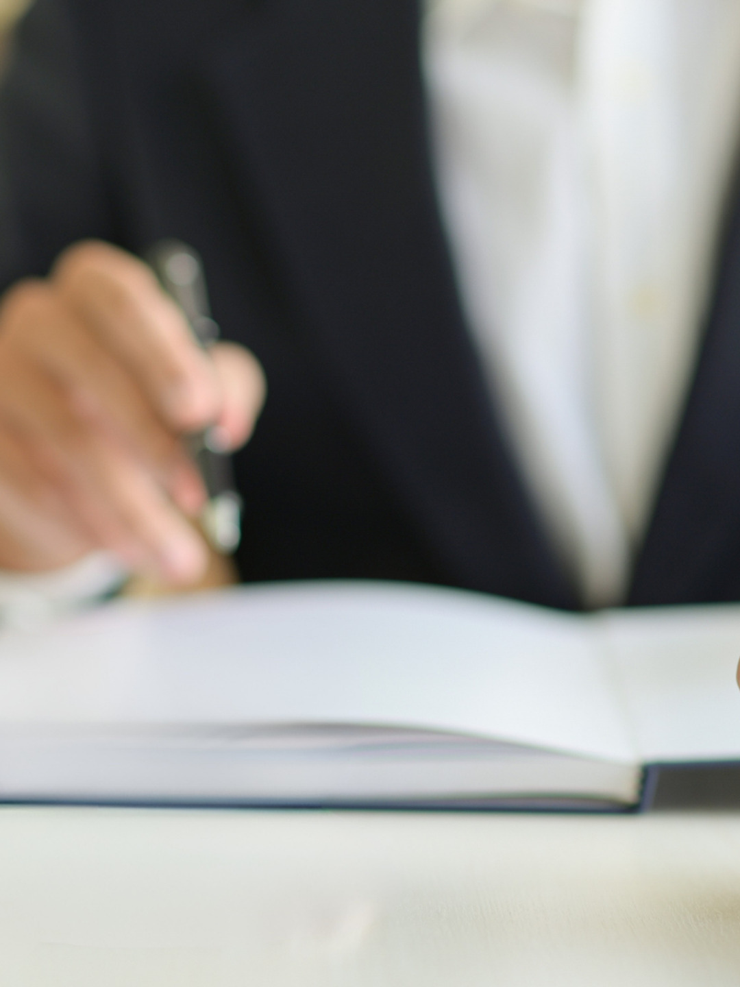 Två personer sitter vid ett bord med en bok och en penna.