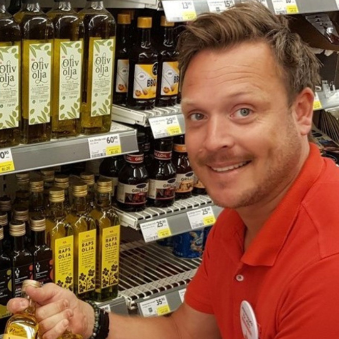 En man som håller en vinflaska i en butik.
