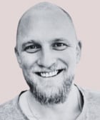 Ett svartvitt foto av en leende man.
