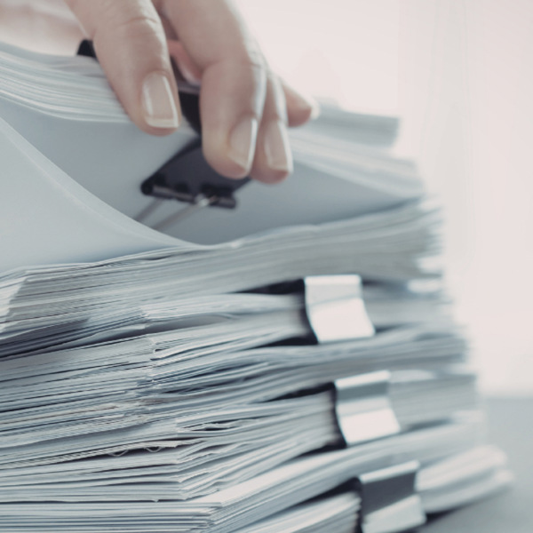 En person håller i en bunt papper.