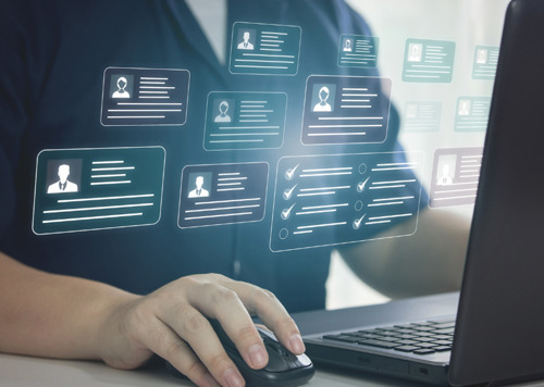 En person som skriver på en bärbar dator med många ikoner som kommer ut ur skärmen.